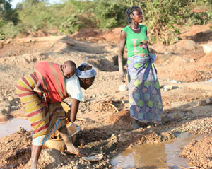 A woman and child and a pregnant woman mind for gold near a rural village in Burkina Faso Oct. 21. (J.D. Long-Garcia/CATHOLIC SUN)