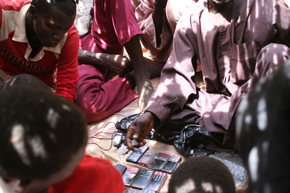 A Nigerien vendor negotiates cell phone prices with customers. (J.D. Long-Garcia)