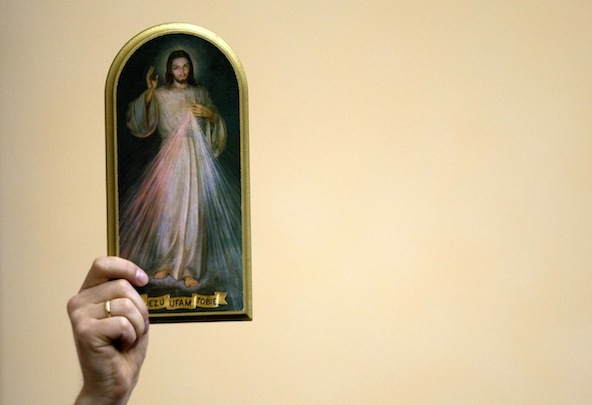 A painting depicting Jesus of Divine Mercy is held among the faithful as Pope Benedict XVI leads the "Regina Coeli" prayer from the balcony of his residence in Castel Gandolfo, Italy in this April 2009 file photo. (CNS photo/Max Rossi, Reuters)