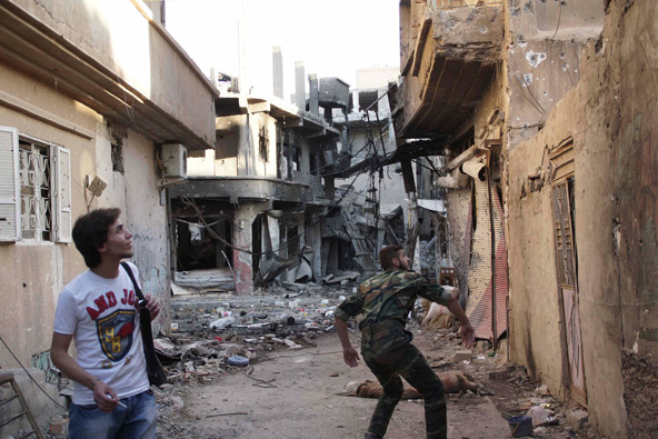 A Free Syrian Army fighter throws an improvised hand grenade toward forces loyal to Syria's President Bashar al-Assad in Deir al-Zor May 15. Archbishop Francis A. Chullikatt, papal nuncio to the United Nations, conveyed to the U.N. General Assembly May 1 5 Pope Francis' "grave concern" about the "unceasing spiral of violence" in Syria and expressed hope the international community can facilitate a process to bring peace to that nation and secure the release of victims of kidnapping, including a Greek Or thodox bishop and a Syriac Orthodox bishop. (CNS photo/Khalil Ashawi, Reuters)