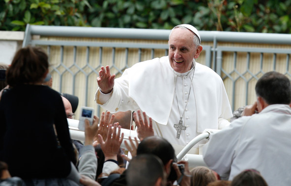 Pope Francis greets people after celebrating Mass at Sts. Elizabeth and Zechariah Parish on the outskirts of Rome May 26. The pope gave first Communion to 16 children at the parish. (CNS photo/Paul Haring)