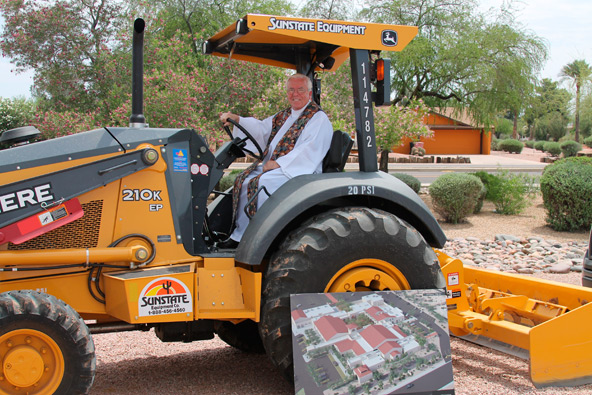 Fr. Patrick Robinson, pastor, poses on construction equipment during a May 5 groundbreaking to build and refresh Blessed Sacrament Parish in Scottsdale. (Ambria Hammel/CATHOLIC SUN)