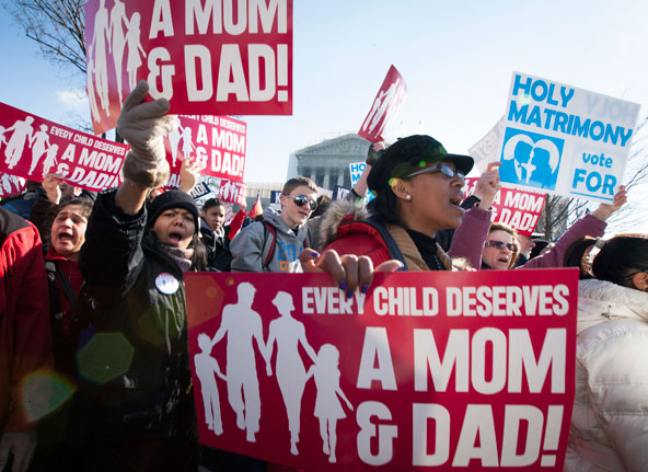 People demonstrate outside the Supreme Court building in Washington in this photo from late March, when the court heard oral arguments in two same-sex marriage cases. The court ruled as unconstitutional the federal Defense of Marriage Act, or DOMA, in a 5-4 decision issued June 26. In a separate case, the court sent back to lower courts a challenge to California's Proposition 8, the voter-approved initiative barring same-sex marriage. (CNS photo/Nancy Phelan Wiechec)