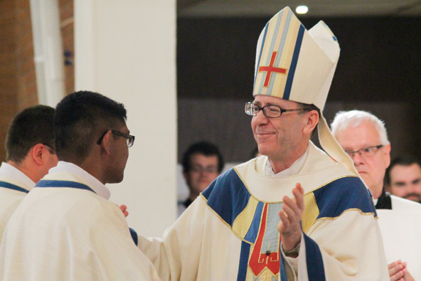 Bishop Thomas J. Olmsted congratulates Fr. Kurt Perera and Fr. Chris Axline during their June 1 ordination at Ss. Simon and Jude Cathedral. (Ambria Hammel/CATHOLIC SUN)