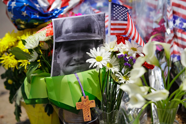 A photo of Wade Parker, one of 19 elite firefighters who died battling an Arizona wildfire, is set among flowers at a makeshift memorial in Prescott July 1. The tragedy marked the greatest loss of life among firefighters in a U.S. wild-land blaze in 80 years. (CNS photo/Joshua Lott, Reuters) (July 1, 2013)