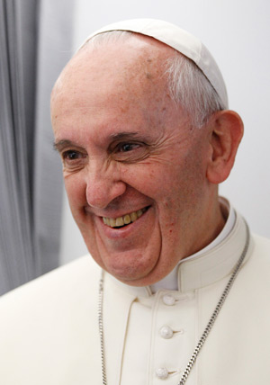 Pope Francis greets members of the media aboard the papal flight to Brazil July 22. The pope is making his first international trip to attend World Youth Day. (CNS photo/Paul Haring)