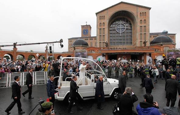 Pope Francis greets pilgrims as he arrives at Brazil's Basilica of the National Shrine of Our Lady of Aparecida July 24. During his visit, the pope entrusted World Youth Day to Mary's maternal protection, but also challenged parents, priests and other ad ult Catholics to give the young people things that the world, with all its wealth, cannot: faith and values. (CNS photo/Nacho Doce, Reuters)