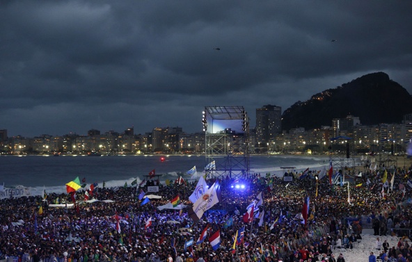 Pilgrims wait for the arrival of Pope Francis at the World Youth Day welcome ceremony on Copacabana beach in Rio de Janeiro July 25. (CNS photo/Paul Haring)