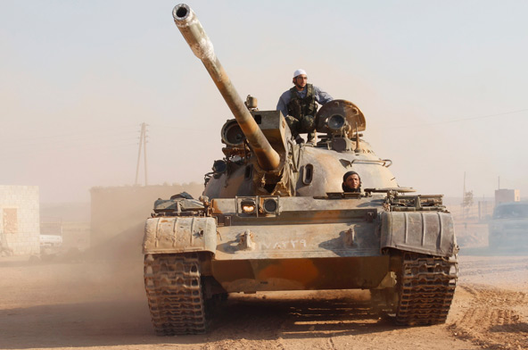Free Syrian Army fighters drive a captured Syrian military tank in Khanasir Aug. 29. As speculation mounted about air strikes on Syria, Western church leaders warned military intervention could lead to an escalation of hostilities. (CNS photo/Molhem Bara kat)