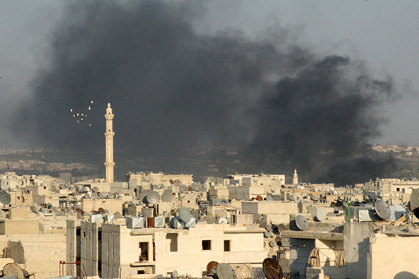 Smoke rises amid buildings in Aleppo, Syria, Sept. 4. Even with just war theory as a guide, analysts say the answers remain murky to moral and ethical questions about whether a military strike is the appropriate response to what U.S. officials believe was a chemical weapons attack on Syrian civilians. (CNS photo/Ammar Abdulla, Reuters)