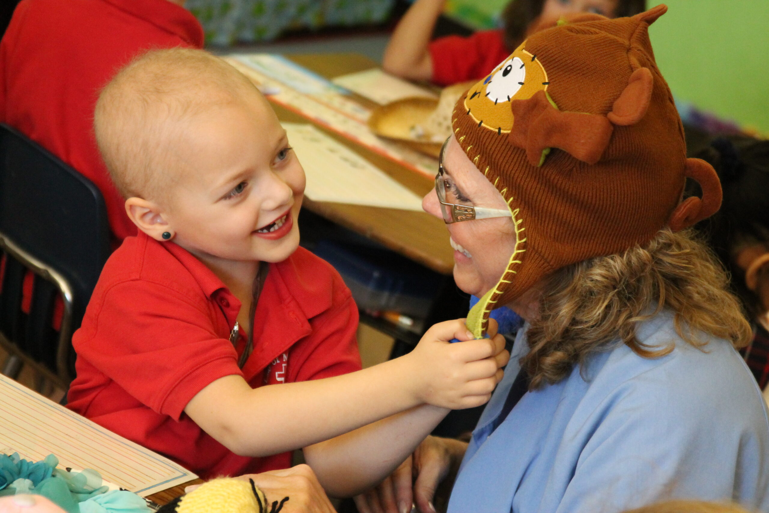 Aututmn Chapman checks out that hat Shannon David, school nurse, wore in honor of Tip Your Hat to Autumn fundraiser Oct. 31 at Our Lady of Mount Carmel (Ambria Hammel/CATHOLIC SUN)