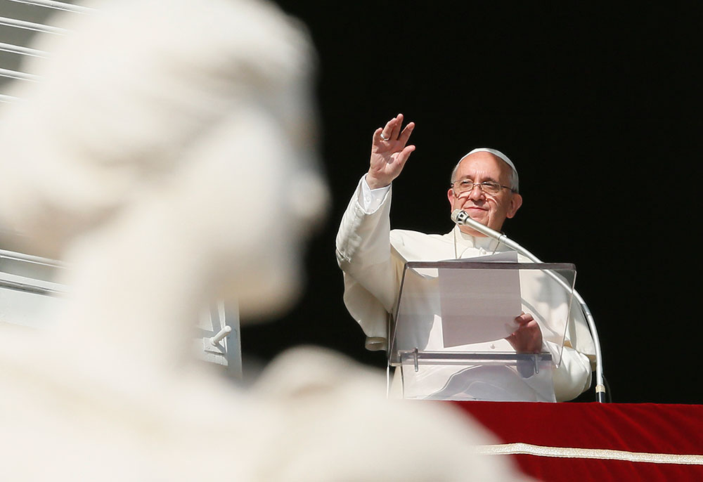 Pope Francis greets the crowd as he leads the Angelus from the window of his studio overlooking St. Peter's Square at the Vatican Nov. 1, the feast of All Saints. (CNS photo/Paul Haring)