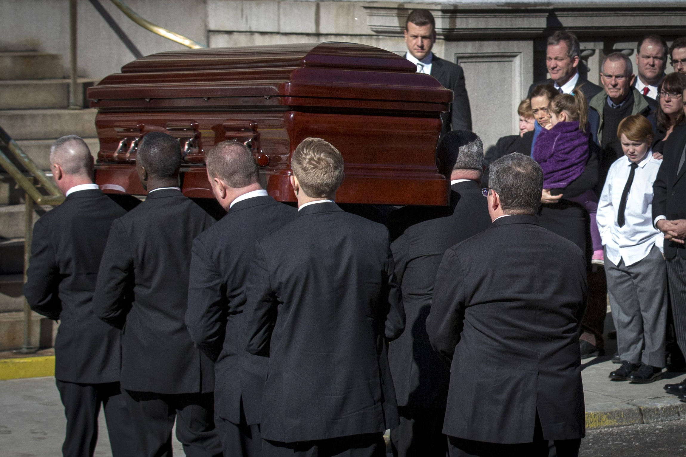 Mimi O'Donnell, former partner of actor Phillip Seymour Hoffman, holds their daughter Willa (in purple) next to their son, Cooper, as Hoffman's casket arrives for his Feb. 7 funeral Mass at St. Ignatius Loyola Church in New York. Hoffman, considered one of the leading actors of his generation, was found dead in his Manhattan apartment Feb. 2, in what police sources described as an apparent drug overdose. (CNS photo/Brendan McDermid, Reuters)