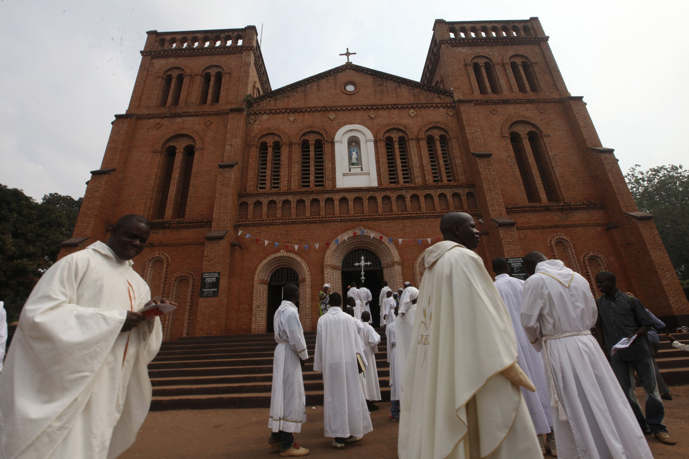 Members of the clergy arrive for Mass in late 2013 at Notre Dame Cathedral of the Immaculate Conception in Bangui, Central African Republic. Catholic leaders in the Central African Republic praised the courage of missionary priests and nuns who remain in the country during the current conflict, despite offers of evacuation. (CNS photo/Luc Gnago, Reuters)