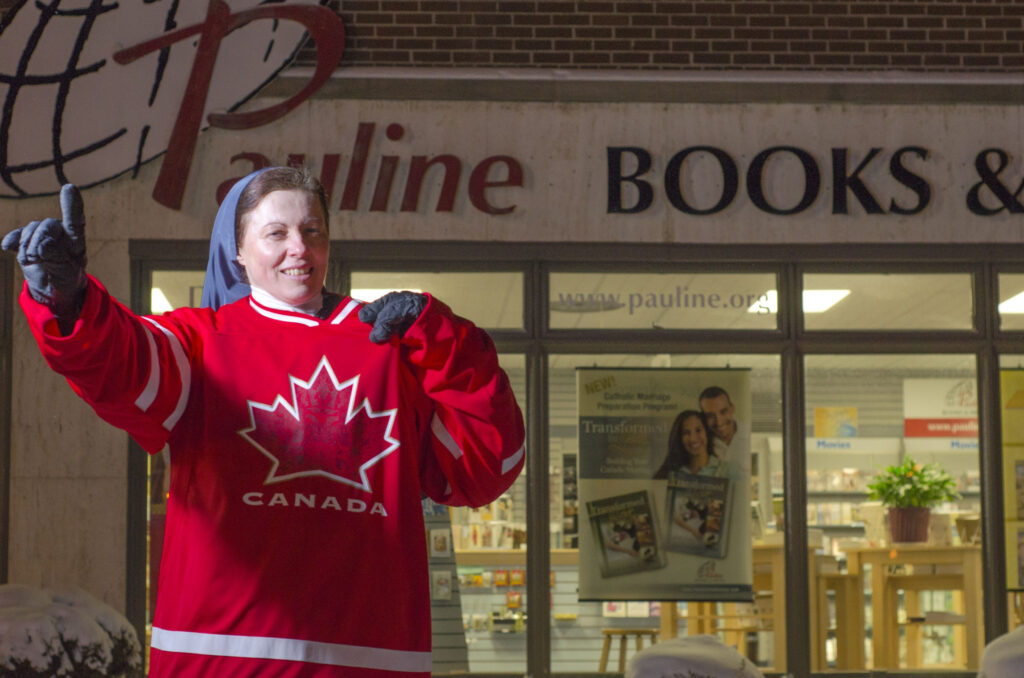 U.S.-born Sister Helena Burns, wearing a Canadian hockey jersey, gives the No. 1 sign outside a bookstore in Toronto Jan. 27. Despite claiming citizenship in both Canada and the United States, Sister Burns always pulls for the maple leaf in international hockey. (CNS photo/Evan Boudreau, Catholic Register)