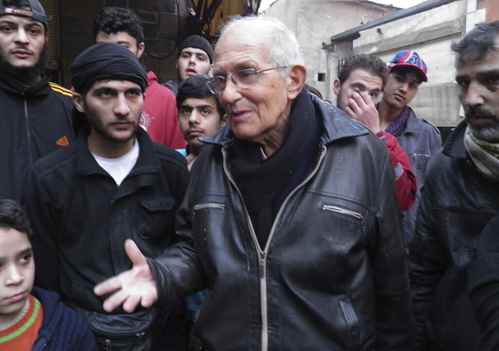 Jesuit Father Frans van der Lugt chats with civilians in early January, urging them to be patient, in the besieged area of Homs, Syria. The Jesuits said April 7 that the Dutch priest, who had worked in Syria since 1966, was beaten by armed men and killed with two bullets to the head. (CNS photo/Thaer Al Khalidiya, Reuters)