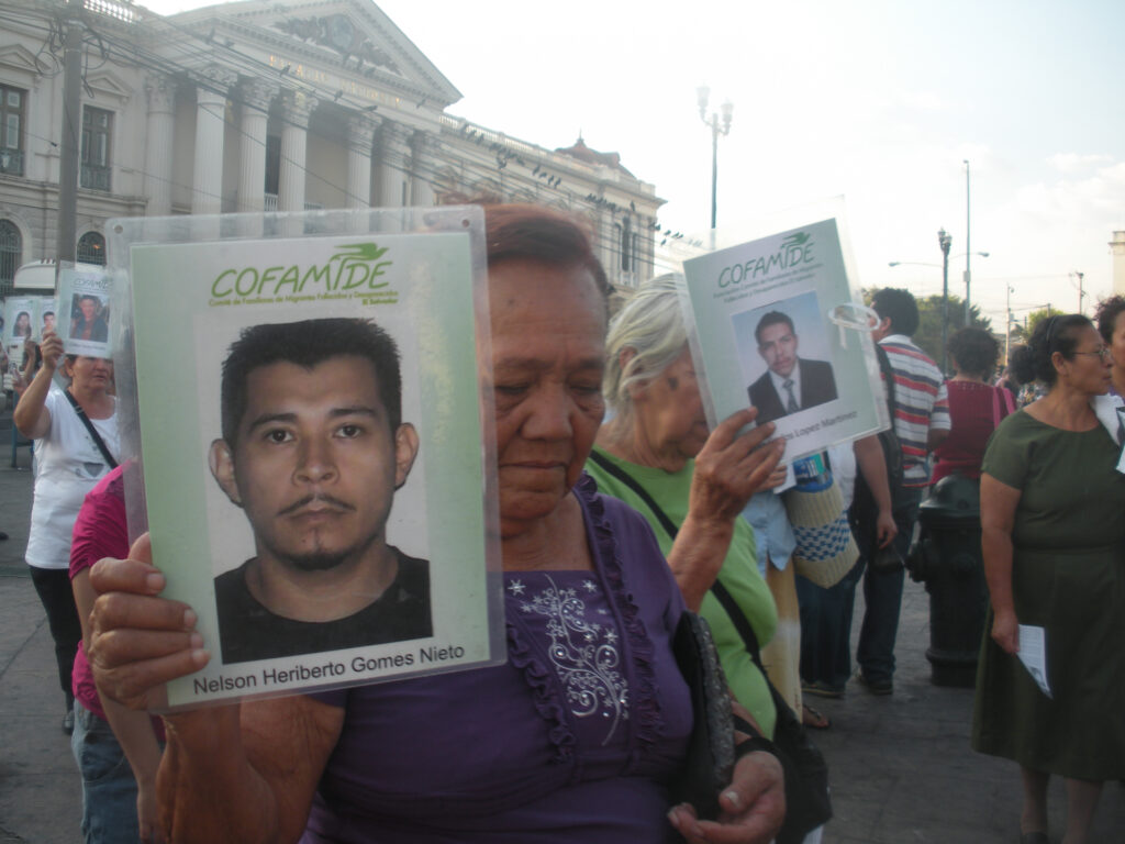Friends and family of migrants who died or disappeared while trying to cross the border between the U.S. and Mexico carry their photos during the Stations of the Cross in San Salvador April 11. About 300 attended the event that seeks prayer for the suffering of migrants. (CNS photo/Rhina Guidos)