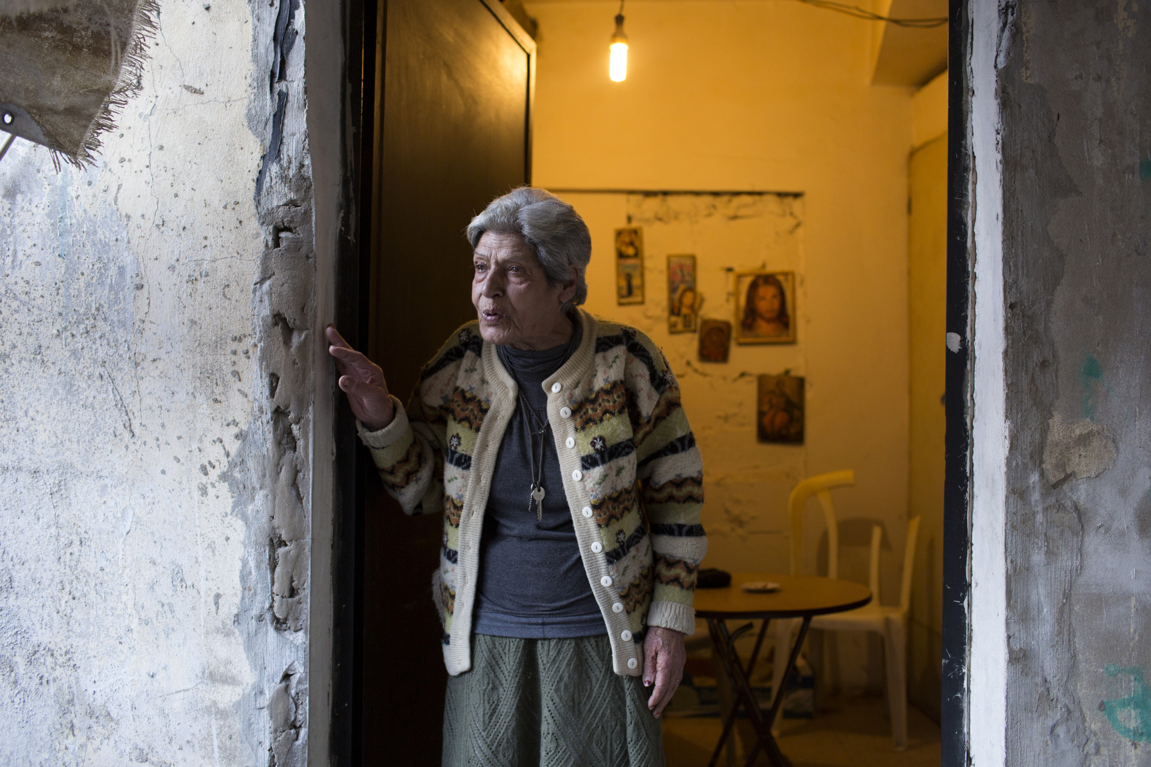 Nayla stands at the front door of her residence March 14 near Beirut, after a visit by students at St. George School in the Zalka section of Beirut. (CNS photo/Dalia Khamissy)