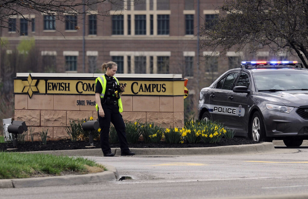 A police officer guards the entrance to the scene of a shooting at the Jewish Community Center of Greater Kansas City in Overland Park, Kan., April 13. A gunman opened fire at two Jewish facilities near Kansas City that day, killing three people, police said. (CNS photo/Dave Kaup, Reuters)