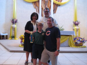 Trent Miller, a sixth-grade scholastic achievement scholar, and his dad, Tim, stand with Our Lady of Perpetual Help Principal Donna Lauro and Fr. Greg Schlarb (photo courtesy of school)