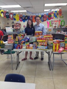 Kathryn Ewing, an eighth-grader, along with her father Nelson Ewing, purchased items for her charity Unaccompanied Minors. (photo courtesy of St. Francis Xavier Catholic School)