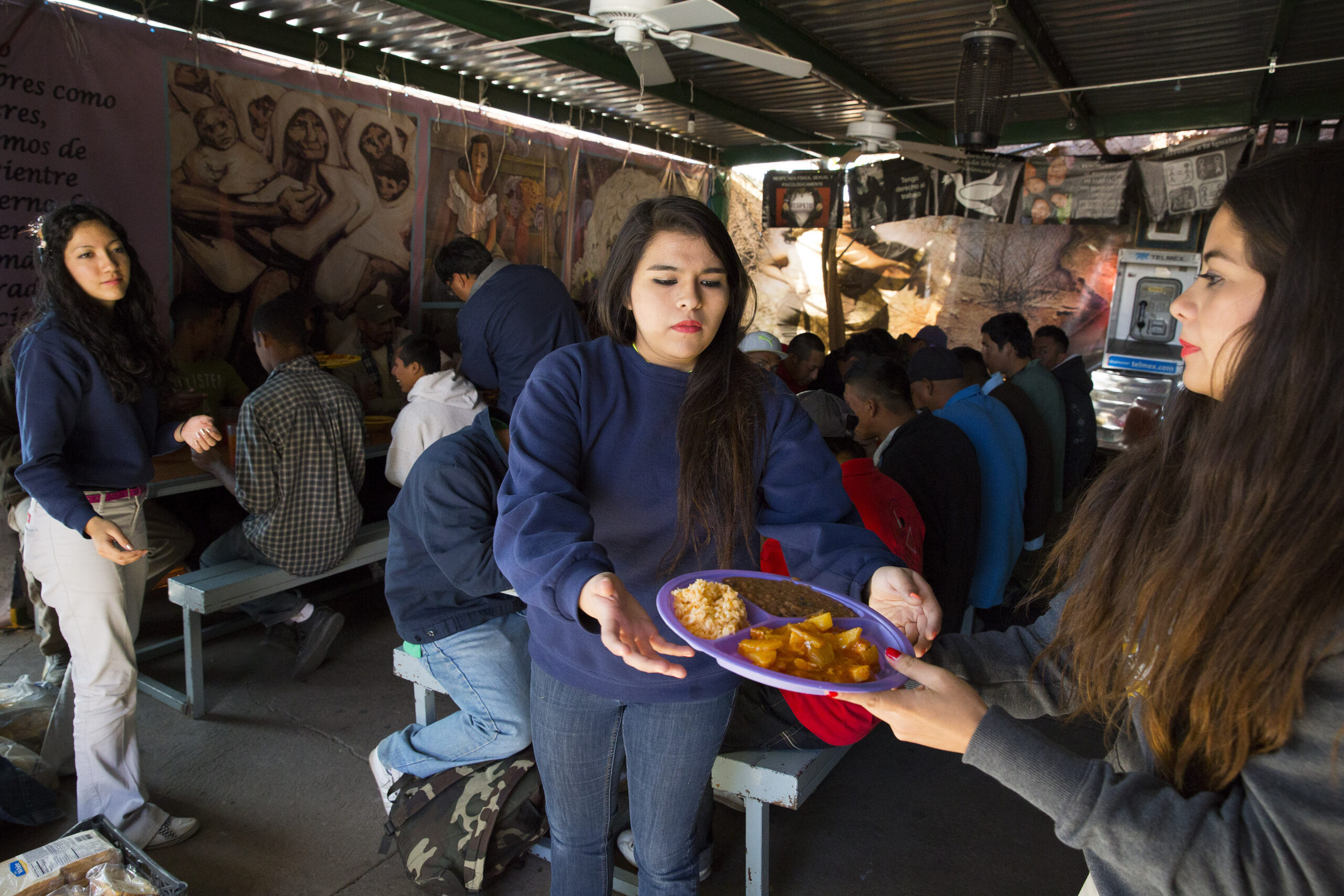 Kino Teens volunteers Angelica Ortiz, Marian Enriquez and Nicole Davison serve dinner to recently deported migrants in the kitchen and dining hall of Centro de Atencion al Migrante Deportado (Aid Center for Deported Migrants) in Nogales, in the Mexican state of Sonora. The volunteer group was started at Lourdes Catholic School in Nogales, Ariz., and supports the Catholic-run Kino Border Initiative, which works for more humane and viable solutions to immigration issues. (CNS photo/Nancy Wiechec)