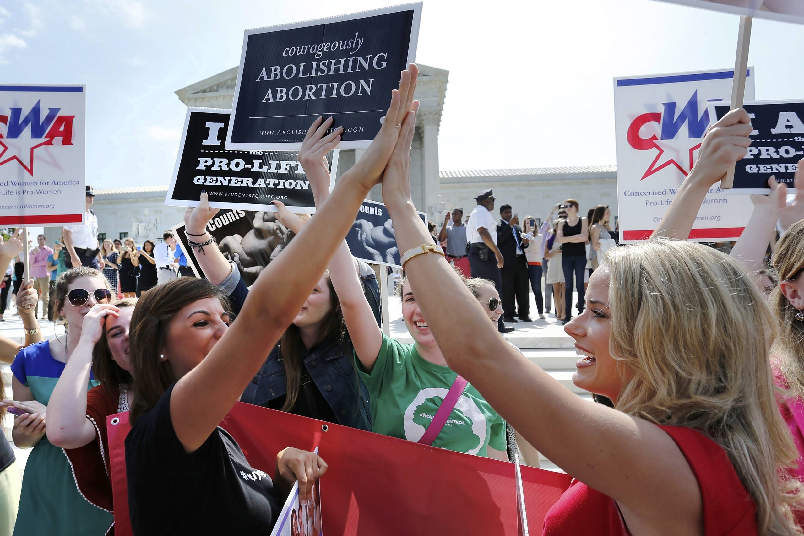 Pro-life demonstrators celebrate June 30 outside the U.S. Supreme Court in Washington as its decision in the Hobby Lobby case is announced. The high court ruled that owners of closely held corporations can object on religious grounds to being forced by the government to provide coverage of contraceptives for their employees. (CNS photo/ Jonathan Ernst)
