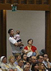 People hold children as Pope Francis opens the annual convention of the Diocese of Rome in Paul VI hall at the Vatican June 16. In his talk, the pope responded to concerns about the difficulties of keeping families active in parish life. (CNS photo/Paul Haring)