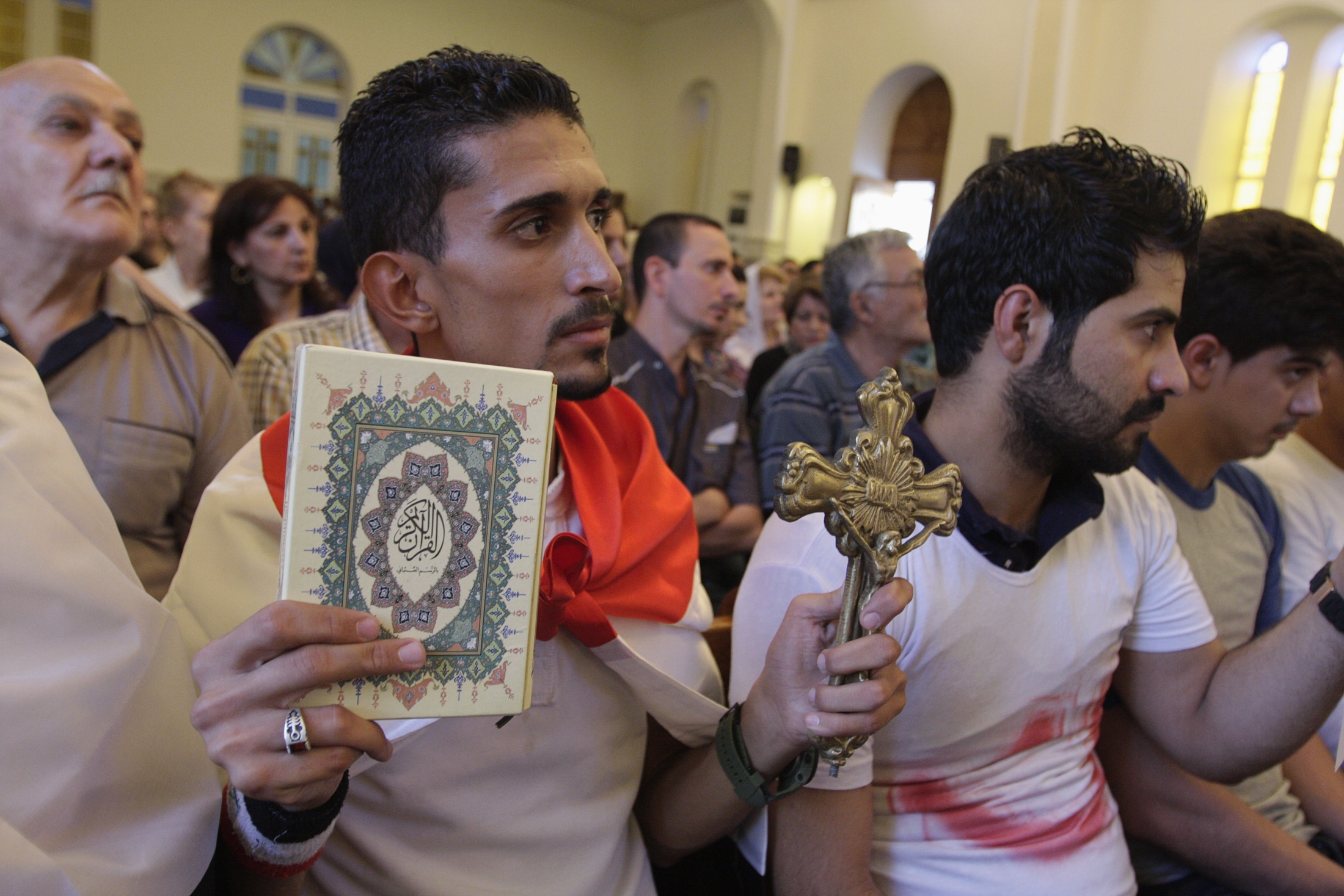 An Iraqi man carrying a cross and a Quran attends Mass at Mar Girgis Church in Baghdad July 20. Pope Francis called for prayers, dialogue, and peace, as the last Iraqi Christians flee the Iraqi city of Mosul. (CNS photo/Ahmed Malik, Reuters)