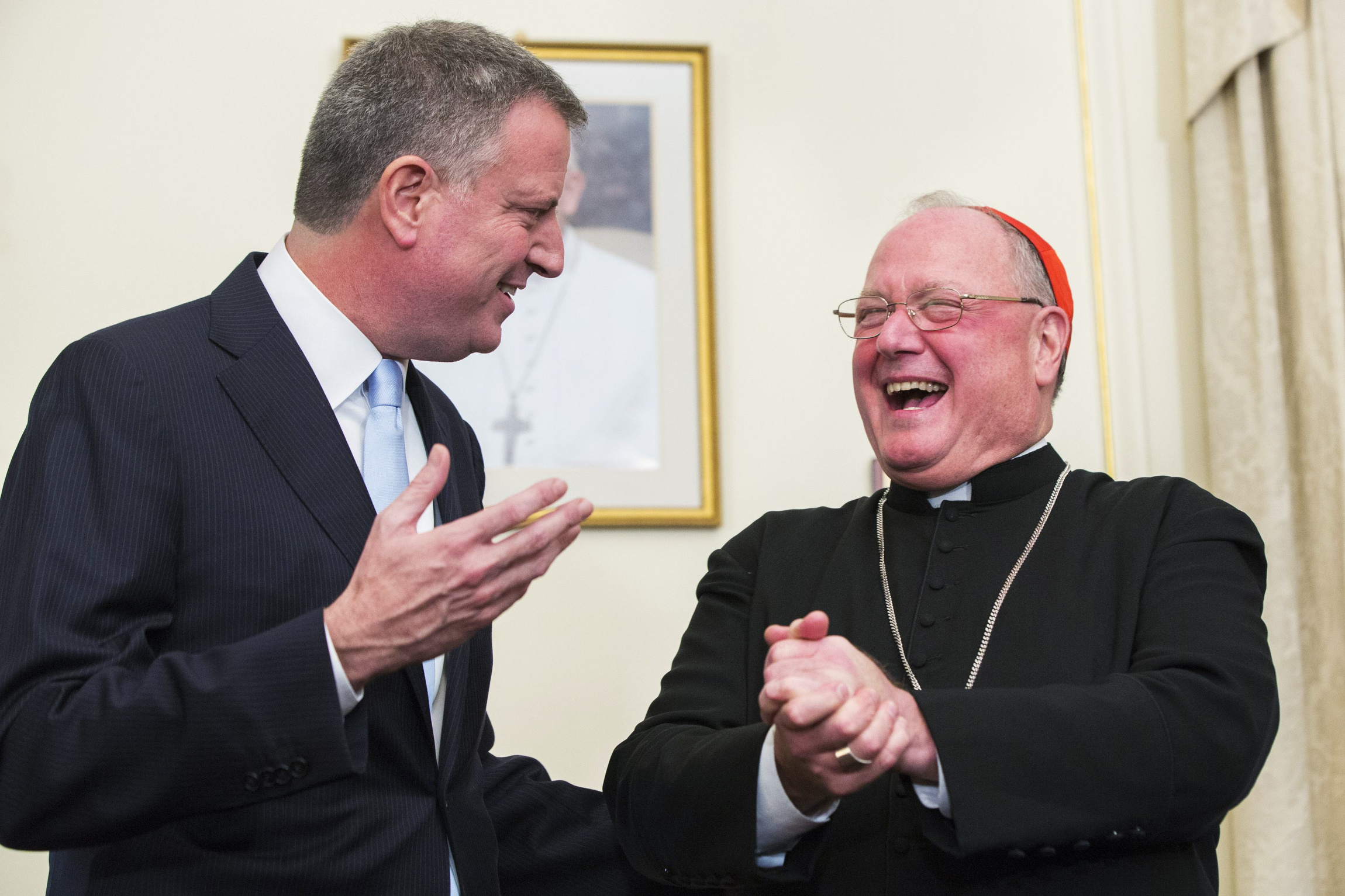 New York City Mayor Bill de Blasio laughs with New York Cardinal Timothy M. Dolan following a meeting at the cardinal's residence in the Manhattan borough of New York Jan. 13. De Blasio met with Cardinal Dolan for the first time since he took office, declaring he will join forces with the cardinal to convince Pope Francis to visit New York City. (CNS photo/Lucas Jackson, Reuters)