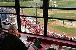 Fr. Craig Collison, a priest in the Diocese of Sioux City, Iowa, watches baseball action from the announcer's booth June 4 as the Sioux City Explorers play the Gary, Ind., Southshore Railcats. Fr. Collison, a play-by-play announcer for the minor league team, loves baseball and says being at the ballpark in a priest's collar gives him an opportunity to evangelize. (CNS photo/Jerry L. Mennenga, Catholic Globe)
