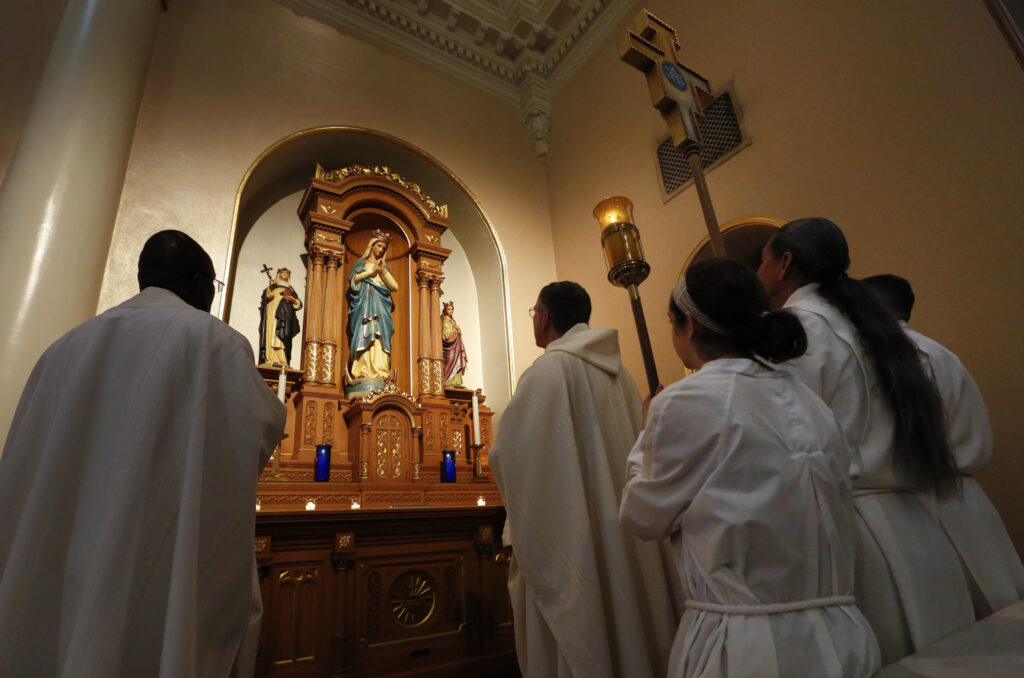 A statue of Mary is venerated during Mass at St. Mary's Basilica in Phoenix Aug. 15, the feast of the Assumption. The basilica built in the mission revival style is marking its 100th year, although its parish community dates back to 1872. St. Mary's Basilica is listed on the National Register of Historic Places. (CNS photo/Nancy Wiechec)