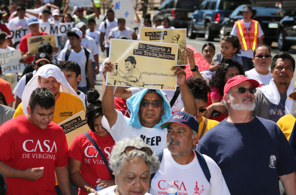 A man displays a sign during an immigration march and rally near the U.S. Immigration and Customs Enforcement headquarters in Washington Aug. 28. (CNS photo/Bob Roller)