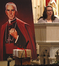 With evidence of her son's alleged miraculous healing boxed and sealed in front of a portrait of Archbishop Fulton J. Sheen, Bonnie Engstrom gives a reading at a 2011 Mass at St. Mary's Cathedral in Peoria, Ill. Bishop Daniel R. Jenky of Peoria, president of the Archbishop Fulton Sheen Foundation, said in March that the seven-member board of medical experts who advise the Vatican Congregation for Saints' Causes has unanimously approved a miracle attributed to the intercession of Archbishop Sheen. (CNS photo/Tom Dermody, The Catholic Post)