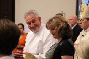 Tony Smith greets his wife during a special Mass instituting him and four other deacon candidates to the ministry of lector Sept. 12. (Ambria Hammel/CATHOLIC SUN)