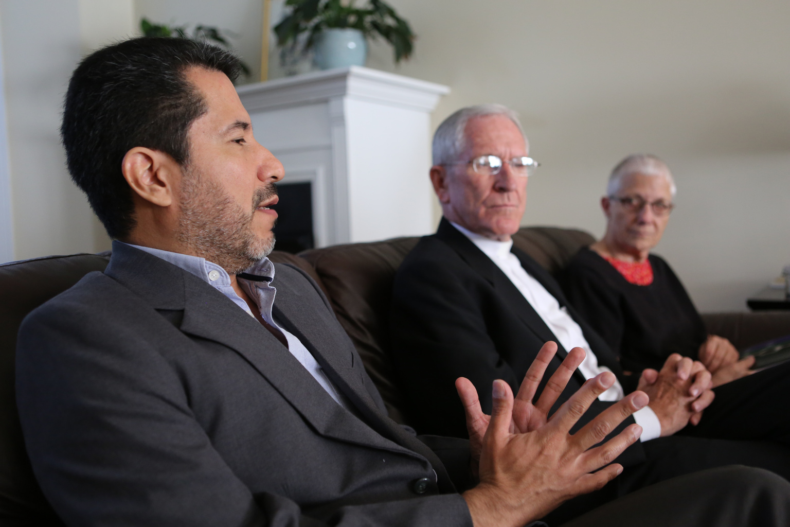Jose Henriquez, secretary-general of Pax Christi International, gestures during an interview at the Maryknoll guest house in Washington Sept. 23. Looking on are the two co-presidents of Pax Christi International, Bishop Kevin Dowling of Rustenburg, South Africa, and Marie Dennis. (CNS photo/Bob Roller)