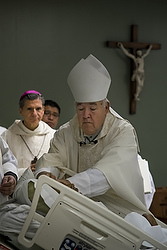 Bishop David R. Choby of Nashville, Tenn., ordains William Carmona as a deacon and a priest during a Sept. 8 Mass in an auditorium at Christus Santa Rosa Medical Center in San Antonio as Archbishop Gustavo Garcia-Siller of San Antonio looks on. Carmona, gravely ill with cancer, was ordained for the Diocese of Nashville. (CNS photo/Rick Musacchio, Tennessee Register)