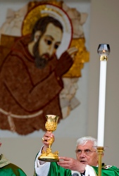 An image of St. Padre Pio is seen in the background as Pope Benedict XVI elevates the Eucharist during Mass outside the Church of St. Pio of Pietrelcina in San Giovanni Rotondo, Italy in this 2009 file photo. The pope said Padre Pio's devotion to the Eucharist, the hours he spent in the confessional and his care for the sick make him a model for priests to imitate. (CNS photo/Max Rossi, Reuters)