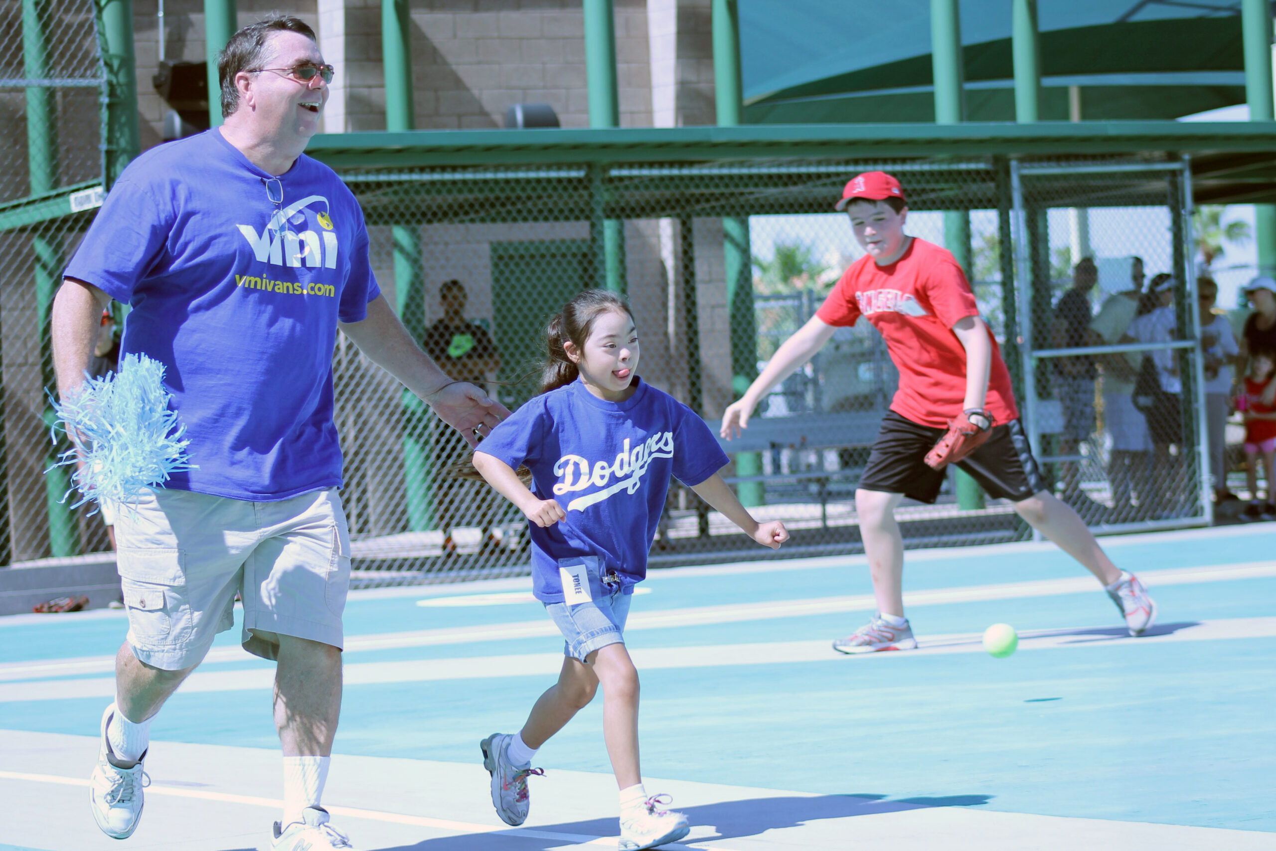Whether they are athletes, coaches or buddies, joy is the common emotion of Miracle League participants who stood for the national anthem and then watched as players ran the bases during this recent Saturday morning game. (Joyce Coronel/Catholic Sun)