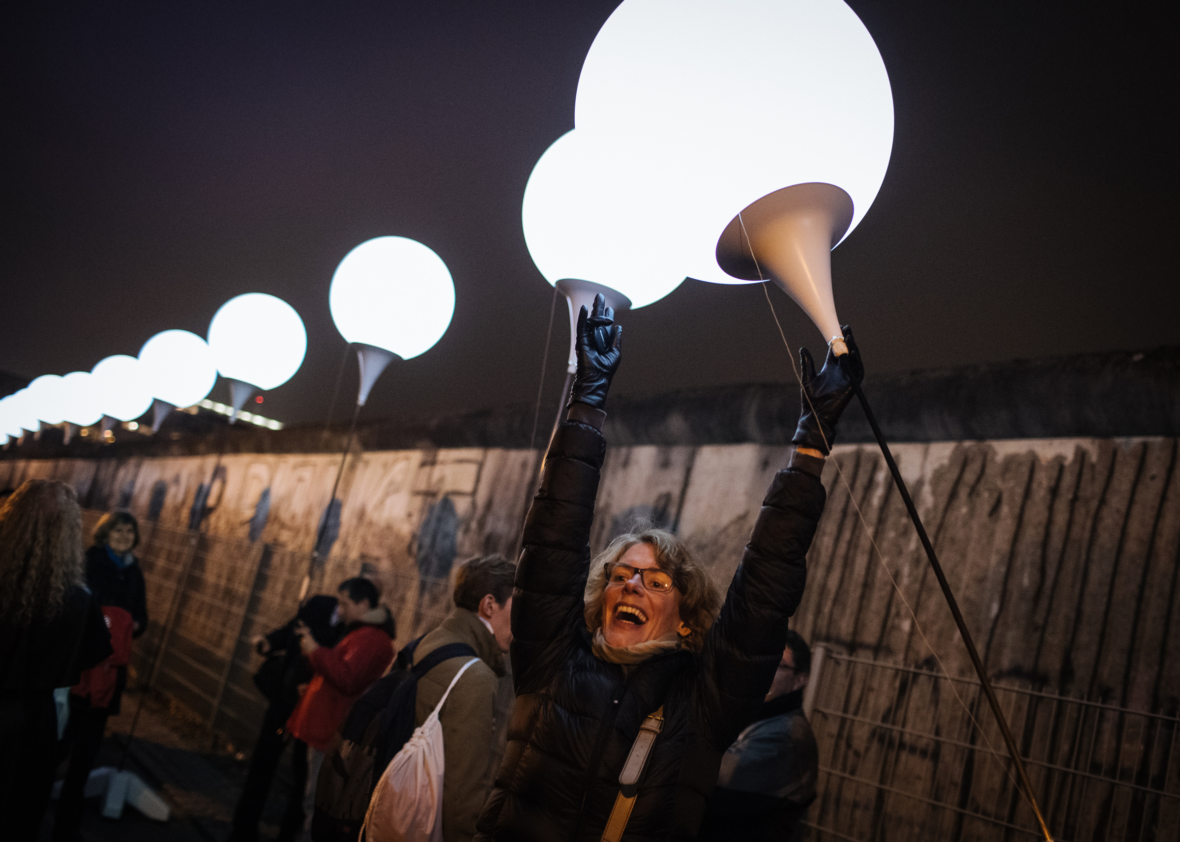 A woman celebrates as she awaits the release of balloons into the sky along the former path of the Berlin Wall in Berlin Nov. 9. Commemorating the 25th anniversary of the fall of the Berlin Wall, Pope Francis said the sudden end to the division of Europe was prepared by the prayers and sacrifice of many people, including St. John Paul II. (CNS photo/Roman Pilipey, EPA)
