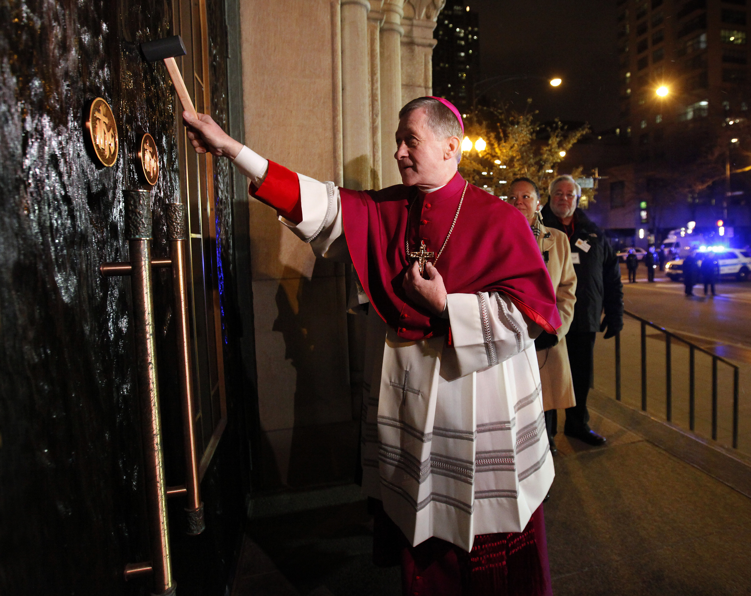 Archbishop Blase J. Cupich uses a mallet to knock three times on the doors of Holy Name Cathedral in Chicago Nov. 17. The archbishop was received inside to start the Liturgy of the Word during a rite to welcome him to the Chicago Archdiocese. (CNS photo/Karen Callaway, Catholic New World)