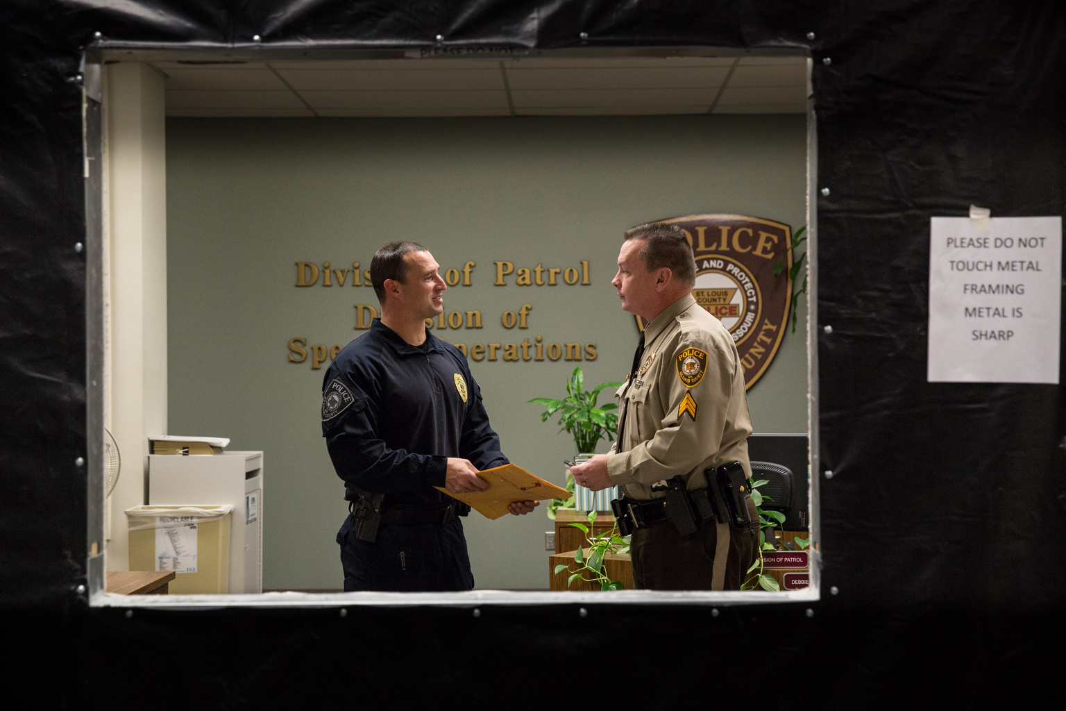 Sgt. Matt Pleviak talks with Sgt. John Wall Nov. 21 at the St. Louis County Police Department in Clayton, Mo. Wall has relied on his Catholic faith during the ongoing crisis in Ferguson, Mo., which began with the fatal shooting of a black teen by a white police officer Aug. 9. The St. Louis County prosecutor announced Nov. 24 a grand jury determined there was not enough evidence to indict Ferguson Police Officer Darren Wilson in the shooting death of Michael Brown. (CNS photo/Lisa Johnston, St. Louis)