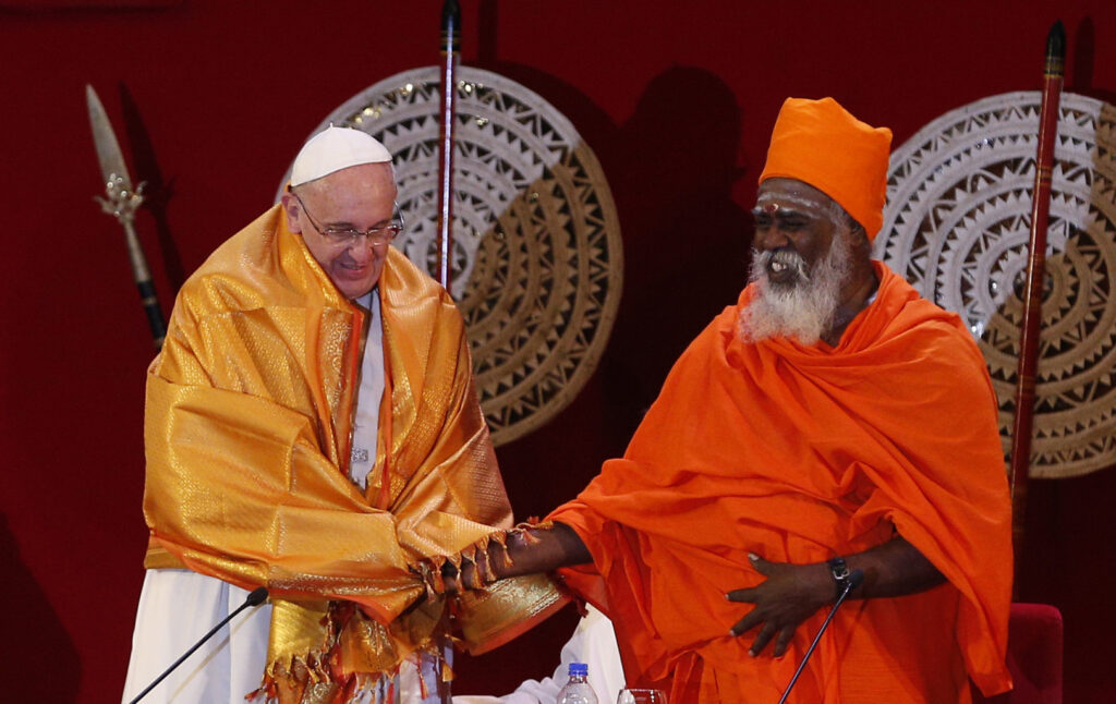 Pope Francis shakes hands with Hindu Kurukkal SivaSri T. Mahadeva after receiving a robe from him during a meeting with religious leaders at the Bandaranaike Memorial International Conference Hall in Colombo, Sri Lanka, Jan. 13. (CNS photo/Paul Haring)