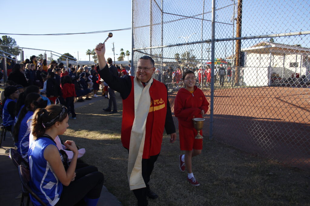 Bishop Eduardo A. Nevares blesses St. Vincent de Paul fans — and opponents — Jan. 22 during a dedication ceremony for the school's revamped ball field. (Ambria Hammel/CATHOLIC SUN)