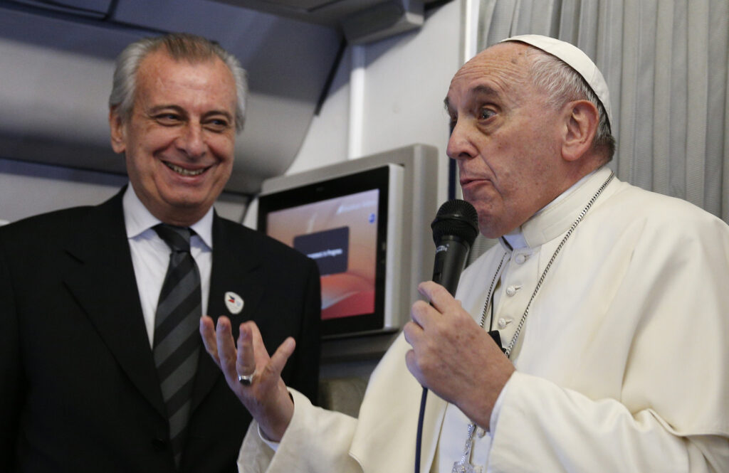 Pope Francis refers to Alberto Gasparri, left, papal trip planner, while answering a question from a French journalist aboard his flight to Manila, Philippines, Jan. 15. In response to the French reporter's question about freedom of religion and freedom of expression, the pope offered a hypothetical example of how Gasparri would receive a punch if he said a swear word against the pope's mother. (CNS photo/Paul Haring)  
