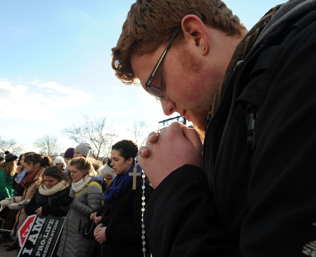 Andrew Juodawlkis prays the rosary with fellow members of Students for Life of Michigan outside the Supreme Court during the annual March for Life in Washington Jan. 22. Tens of thousands took part in the annual event, which this year marked the 42nd anniversary of the Supreme Court's Roe v. Wade decision that legalized abortion across the nation. (CNS photo/Leslie E. Kossoff)