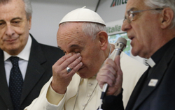Pope Francis wipes his eyes as Jesuit Father Federico Lombardi, Vatican spokesman, right, speaks about French journalists aboard the papal flight to Colombo, Sri Lanka, Jan. 12. Father Lombardi said two French journalists were supposed to be on the plane but were unable to come because they were needed for news coverage of terrorism in France. (CNS photo/Paul Haring)