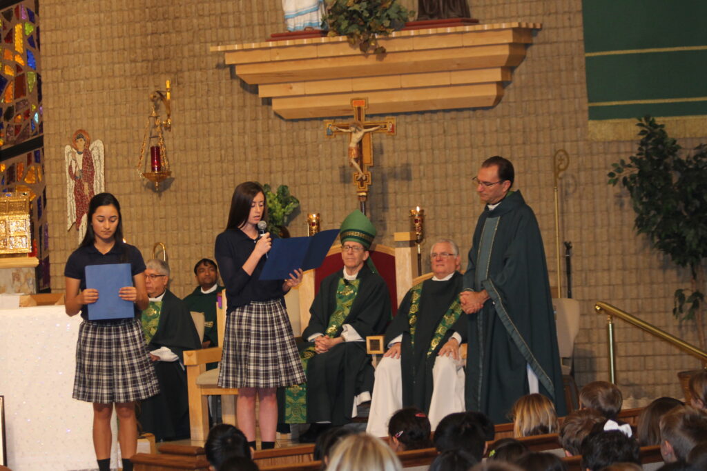 Students from St. Mary-Basha Catholic School read essays they wrote about their Catholic education as Bishop Olmsted and St. Mary Parish's pastor Fr. Dan McBride listen Jan. 30.