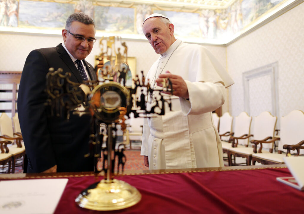 Pope Francis and President Mauricio Funes Cartagena of El Salvador look at a reliquary containing a blood-stained piece of the vestment of Archbishop Oscar Romero during a private audience in the Apostolic Palace at the Vatican May 23. Archbishop Romero was wearing the vestment when he was assassinated while celebrating Mass in 1980. President Funes presented the reliquary as a gift. (CNS photo/Alessandro Bianchi, Reuters)