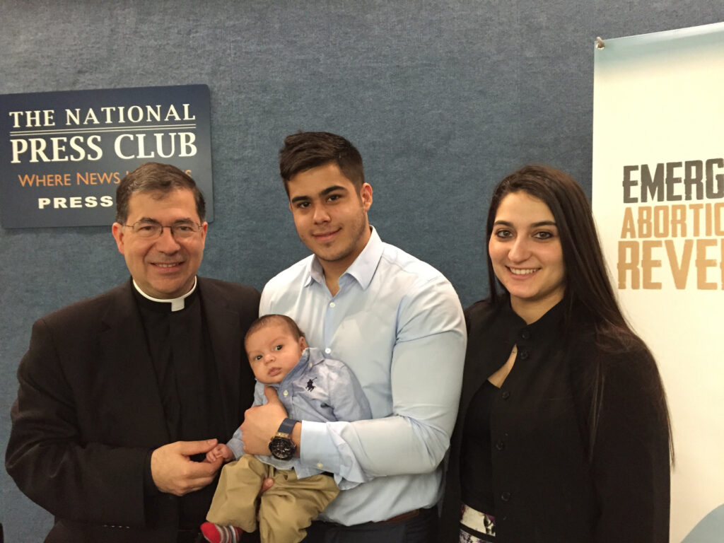 Fr. Frank Pavone, national director of Priests for Life, poses with Chris Caicedo, Andrea Minichini and their son, Gabriel Caicedo, following a news conference at the National Press Club in Washington Feb. 23 to call attention to a protocol to reverse RU-486 medical abortions. (CNS photo/Priests for Life)